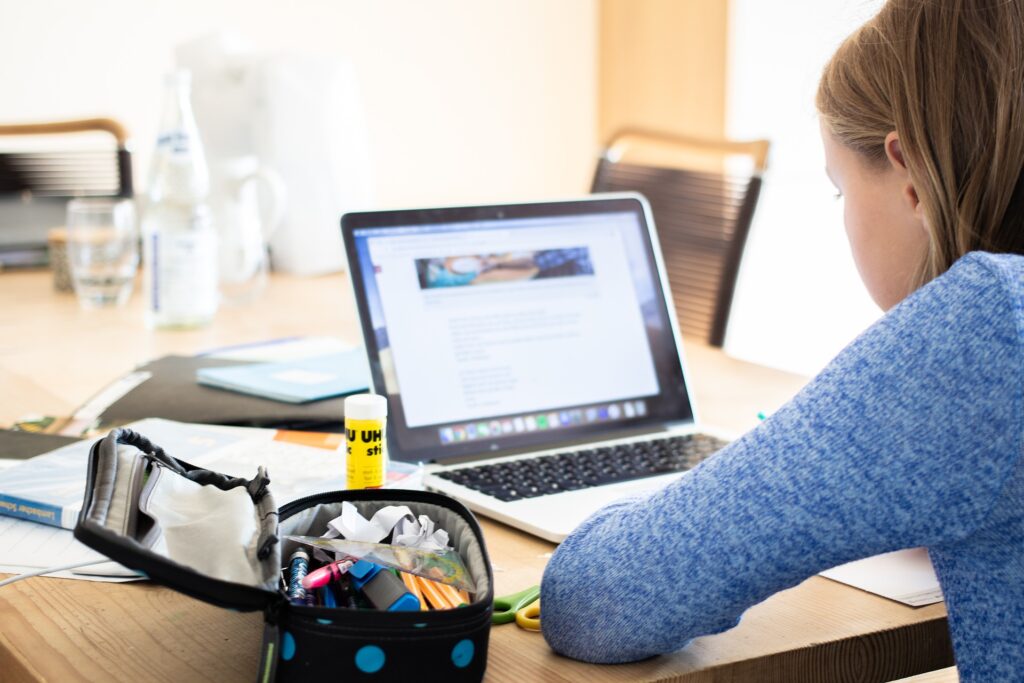 A person sitting at a table with a laptop.