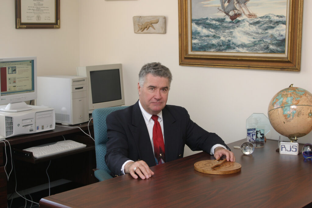 A man sitting at a table in front of a computer.